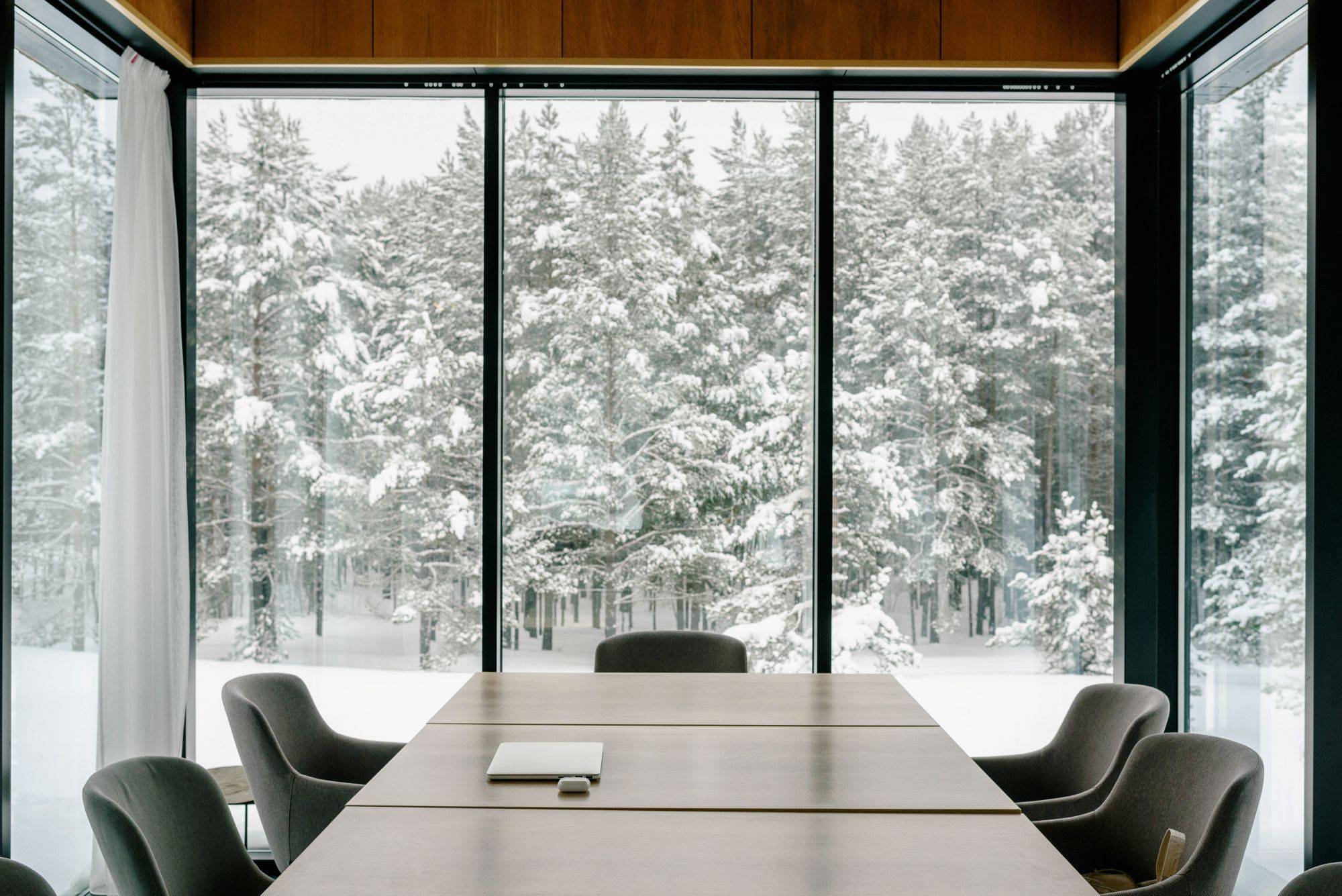 Conference room with a wall of glass onto a snowy forest