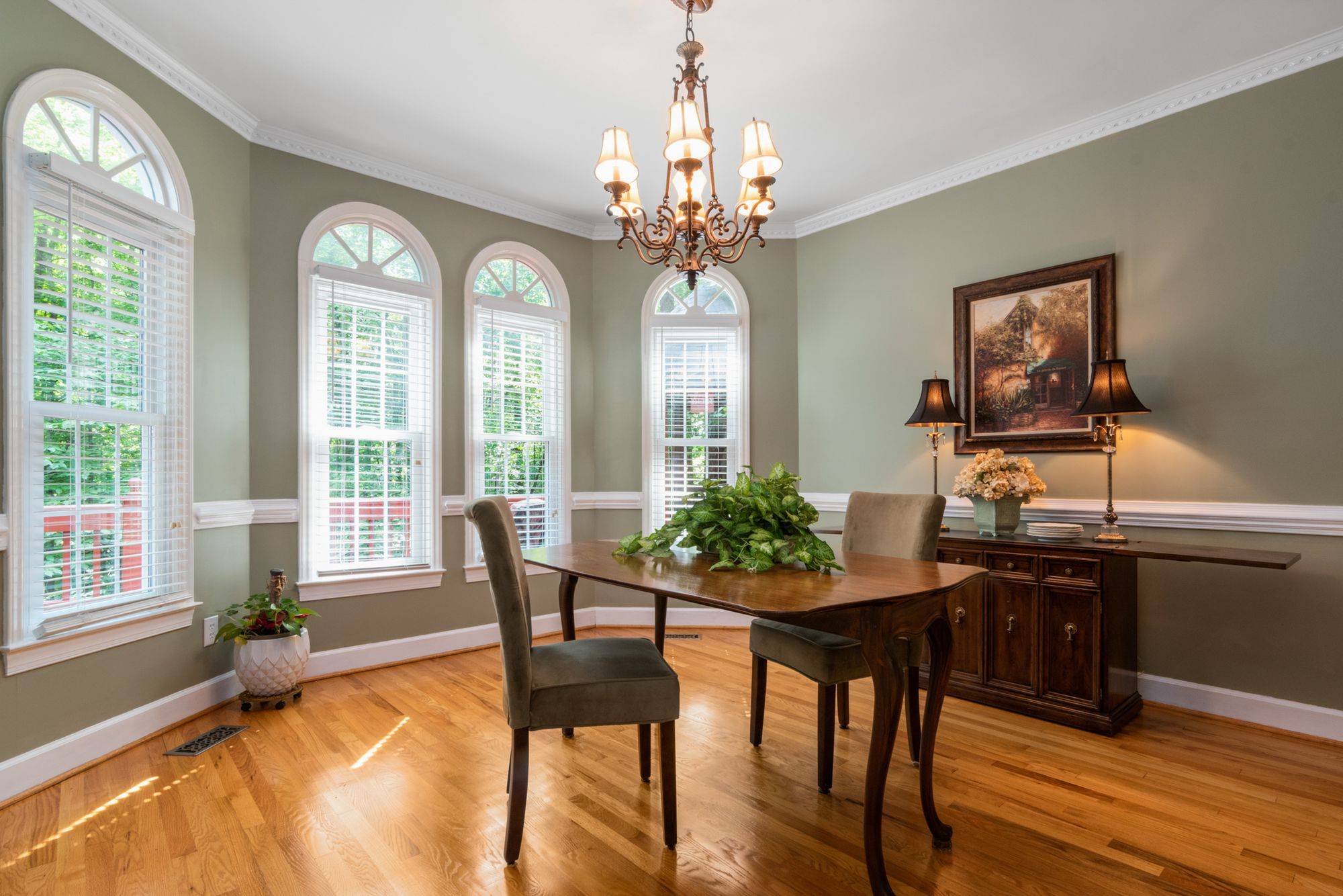 Dining room with arched windows, chair rail and hardwood