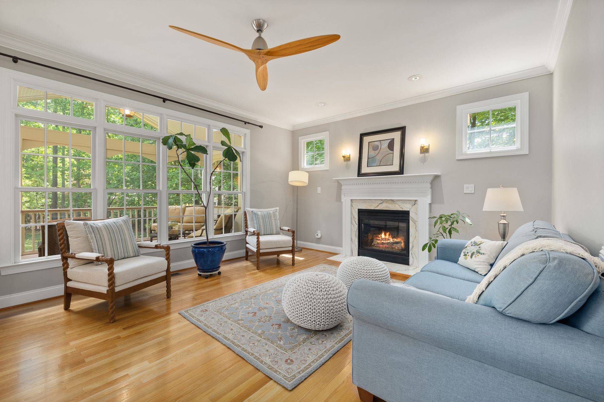 Sunlit living room with a wall of windows and a fireplace